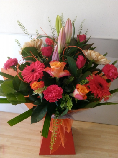 Tutti Frutti - We love this new colour of Gerberas and along with orange and cerise roses, peach blooms, a lily and some carnations in a mix of modern foliage and presented in a box with food and water, it makes a stunning gift for any occasion!
